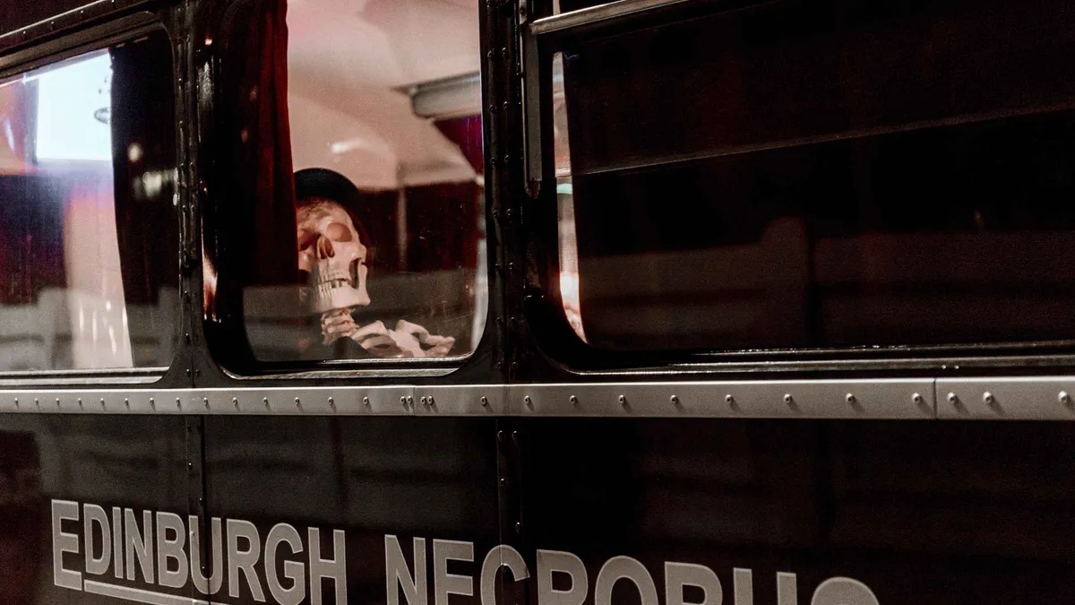 Black vintage double-decker on the Ghost Bus Edinburgh ghost tour along the Royal Mile, Old Town, Scotland