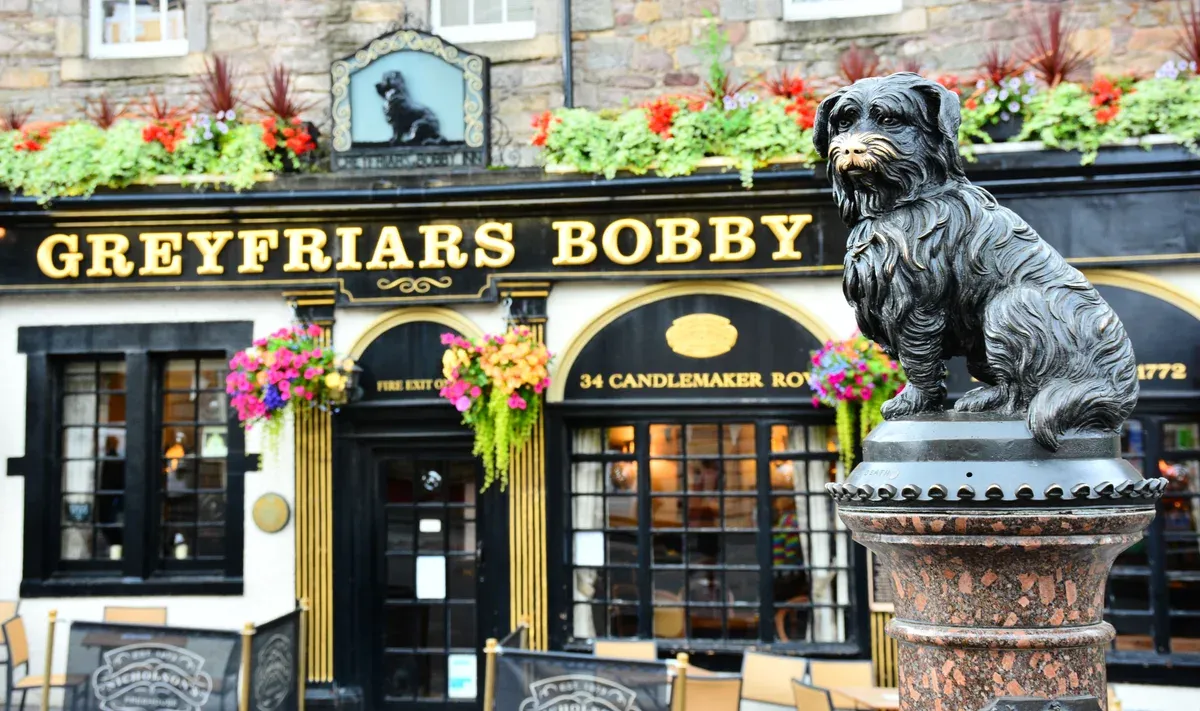 The Greyfriars Bobby statue on its fountain outside the pub on Candlemaker Row, Edinburgh ghost tours, Edinburgh, Scotland
