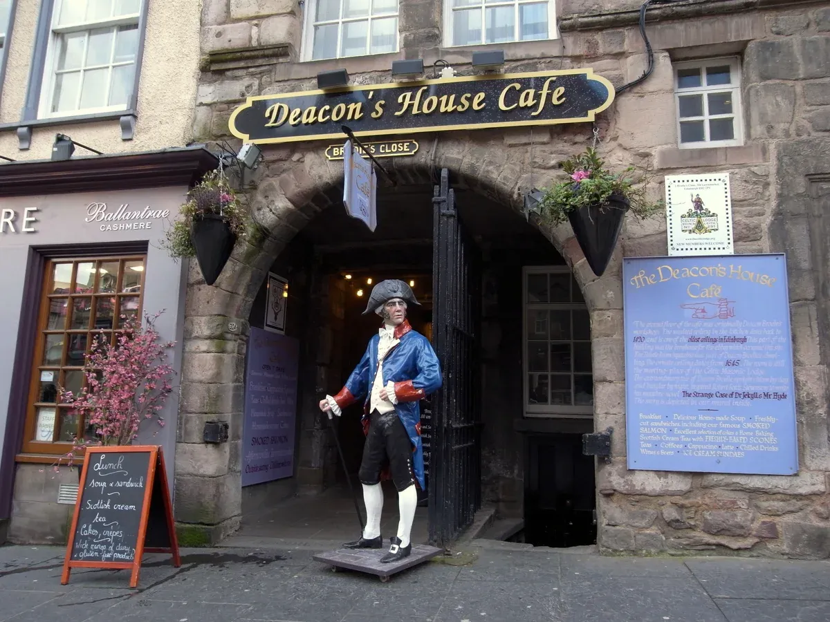 The arched entrance of Brodie's Close with a costumed figure of Deacon Brodie at the door, Edinburgh ghost tours, Edinburgh, Scotland