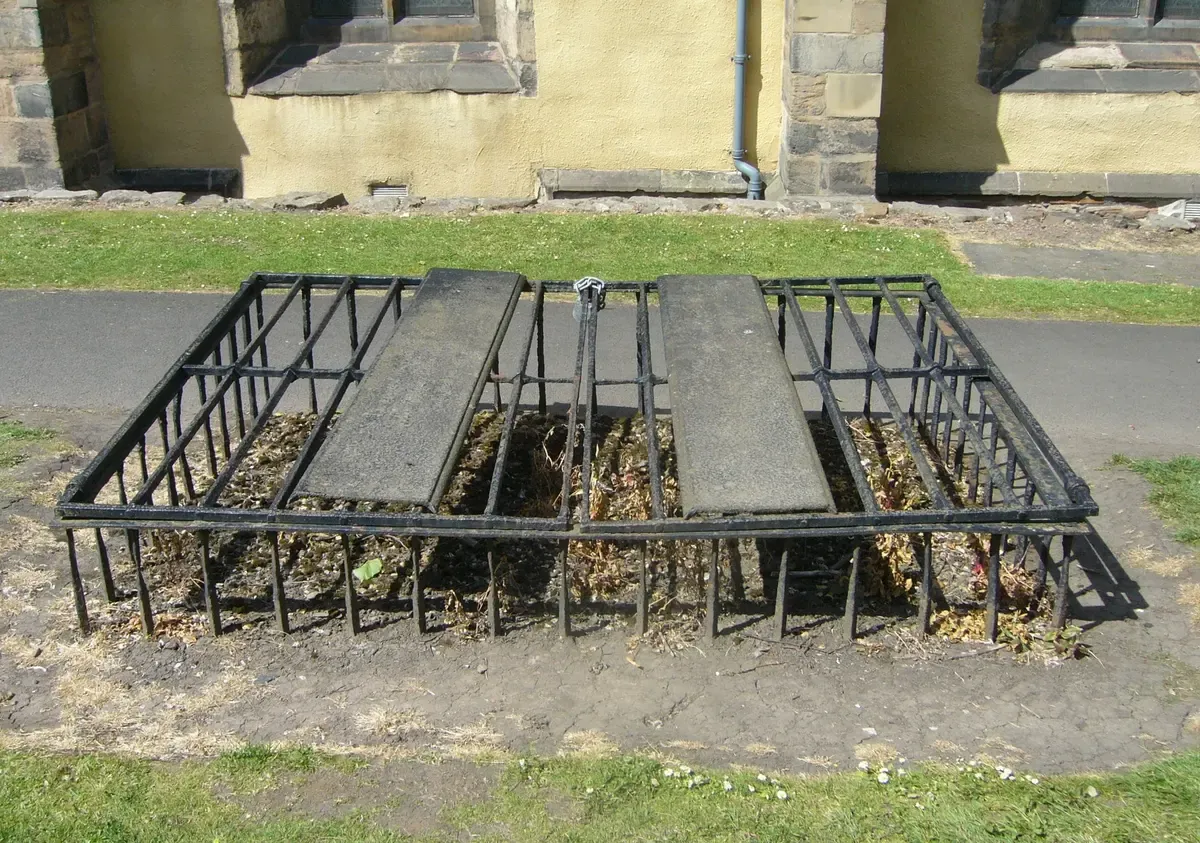 An iron mortsafe cage over two flat slabs in Greyfriars Kirkyard, built to stop body snatchers, Edinburgh ghost tours, Edinburgh, Scotland